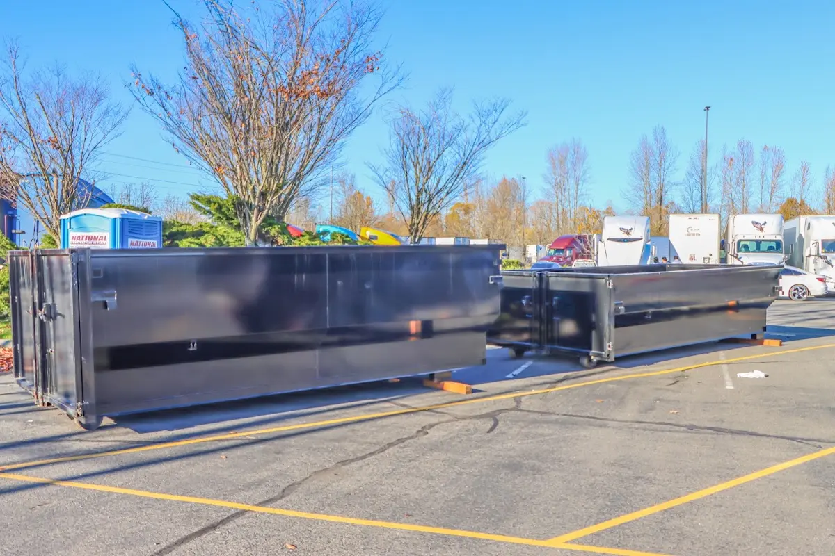 Professional dumpster rental service with roll-off container on residential driveway in West Bloomfield